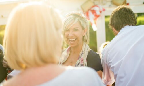 Woman laughing at outdoor event in sun
